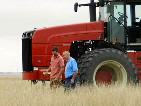 farmers in field in front of tractor